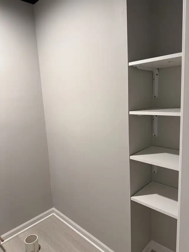 White built-in shelving in a freshly painted grey room
