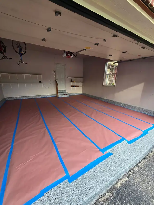 Freshly painted garage with wall storage and the floor covered in protective paper